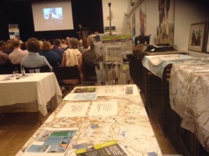 Maps in the foreground, Intrepid explorer JBS on stage.